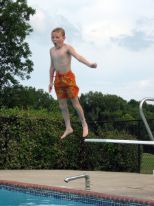 boy jumping into pool